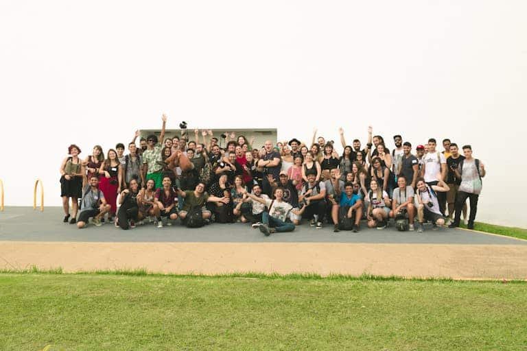 A joyful group of diverse friends celebrating outdoors on a sunny day.